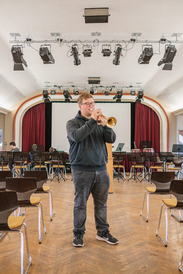 Ein junger Mann spielt Trompete in der Marienschule Bielefeld