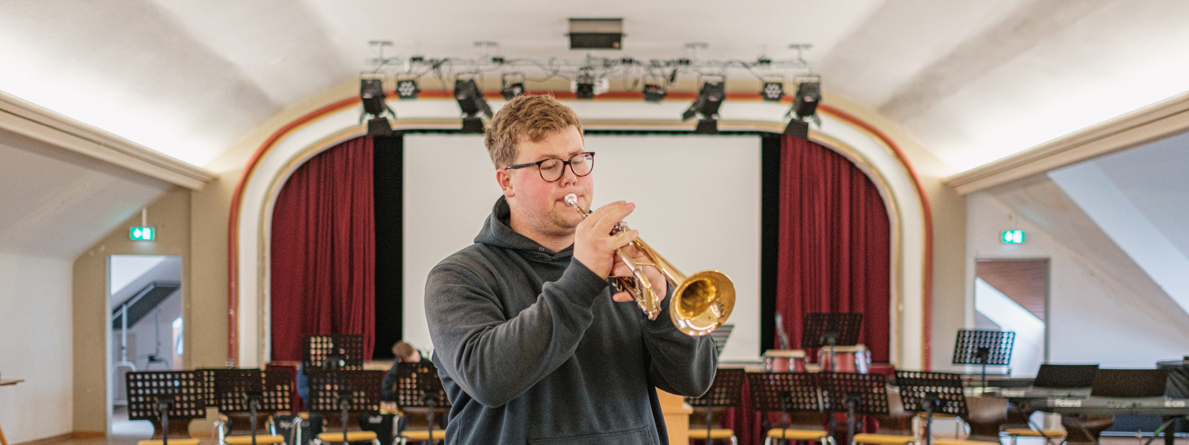 Ein junger Mann spielt Trompete in der Marienschule Bielefeld