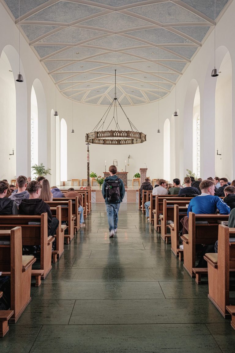 Ein Schüler läuft in Richtung des Altars in der Kapelle der Marienschule Bielefeld
